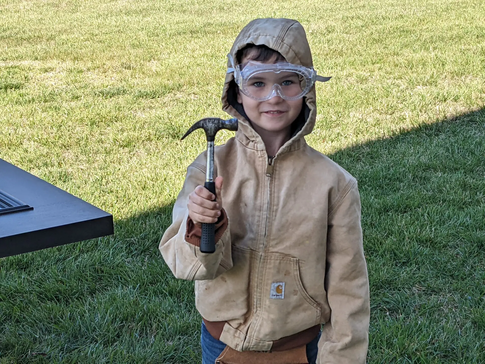 Kid with safety glasses and holding hammer